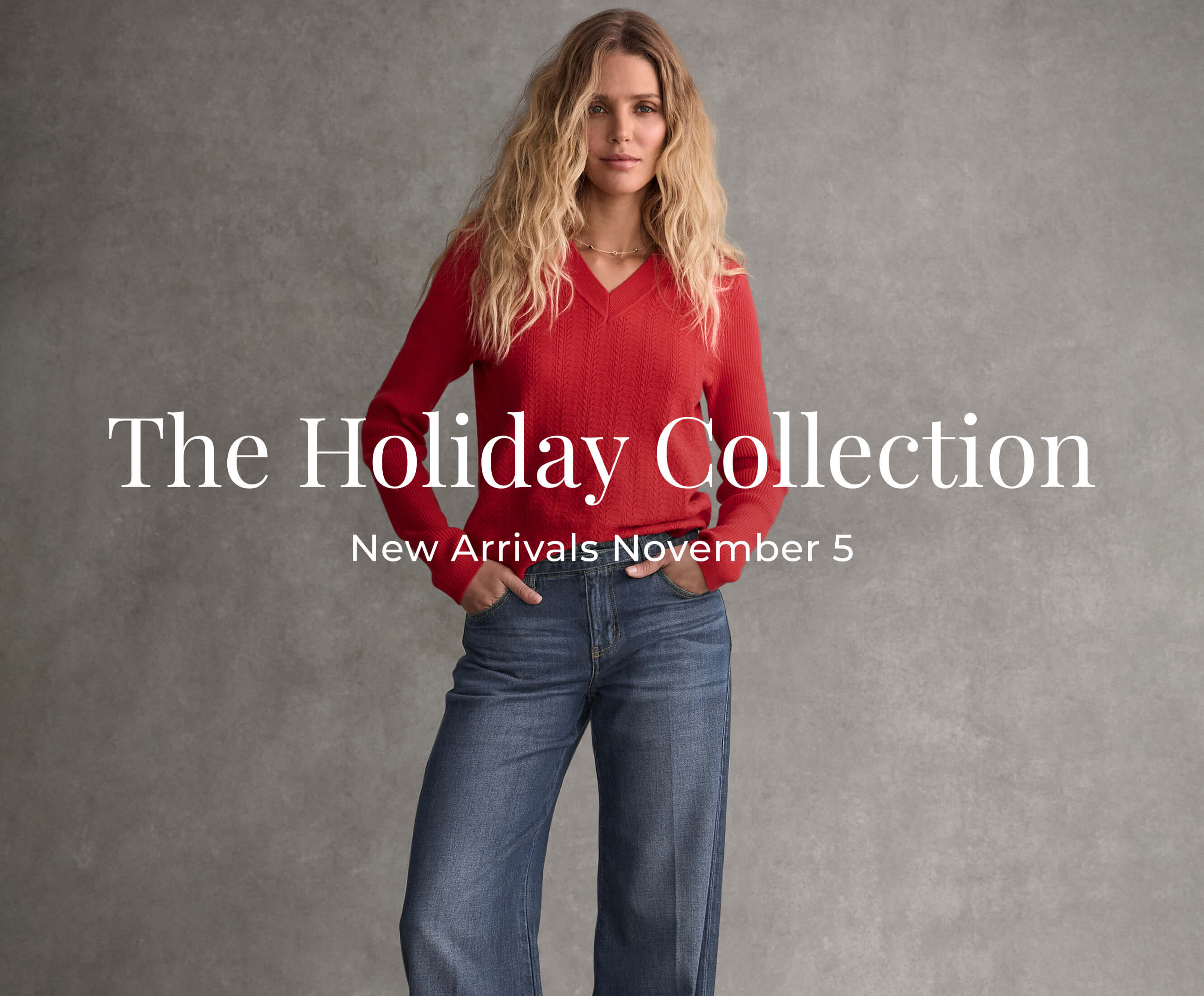 A blonde haired model wearing a red top with a pair of denim bottoms.