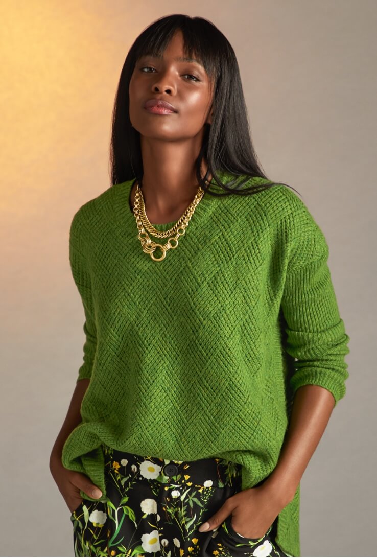 Model Wearing the Basket Weave Pullover in Grass Green, Chi Chi Trouser in Climbing Vine, and the Harness Ring Necklace in Antique Gold.