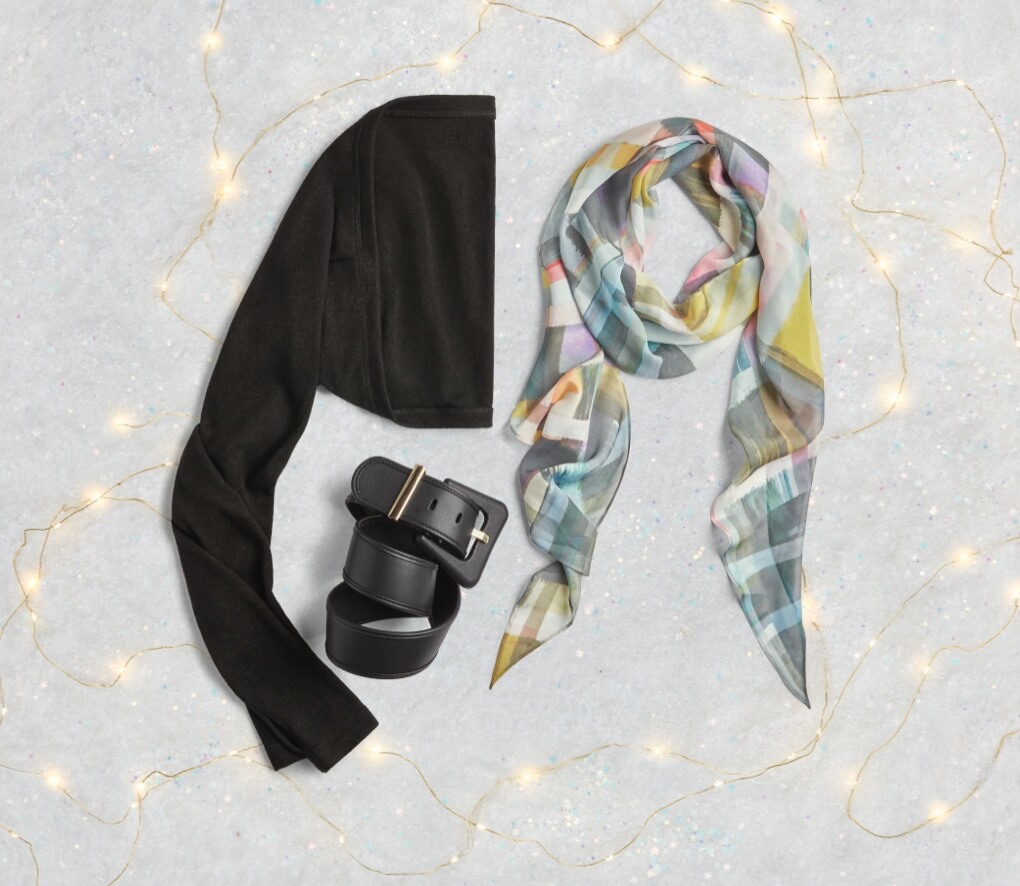 Arm Warmers in Black, Staple Scarf in Effortless Plaid, and Boss Belt in Black with snowflakes and lights as accents.