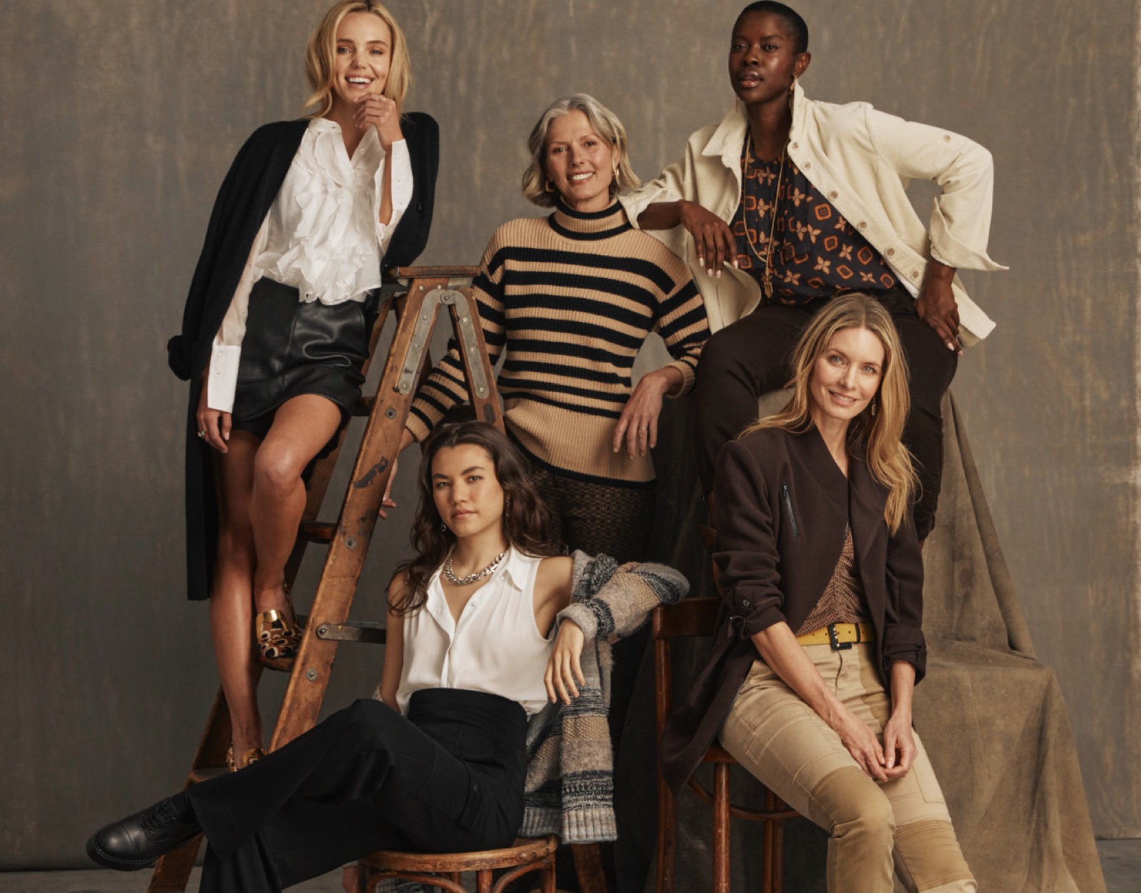 Models modeling the Fall 2023 Collection. First model is wearing Noble Blouse in White, Jett Skort in Black, James Jacket in Black. Second model is wearing Polo Turtleneck in Black and Cream and Director Trouser in Multi. Third model is wearing Louis Top in Medallion Print, Scout Jacket in Bone, and Compass Pant in Dark Chocolate. Fourth model is wearing Poetry Top in White, Boyfriend Cardigan in Multi, and Chargo in Black. Fifth model is wearing Sassy Top in Tile Print, Legacy Topper in Dark Chocolate, and Captain Pant in Khaki.