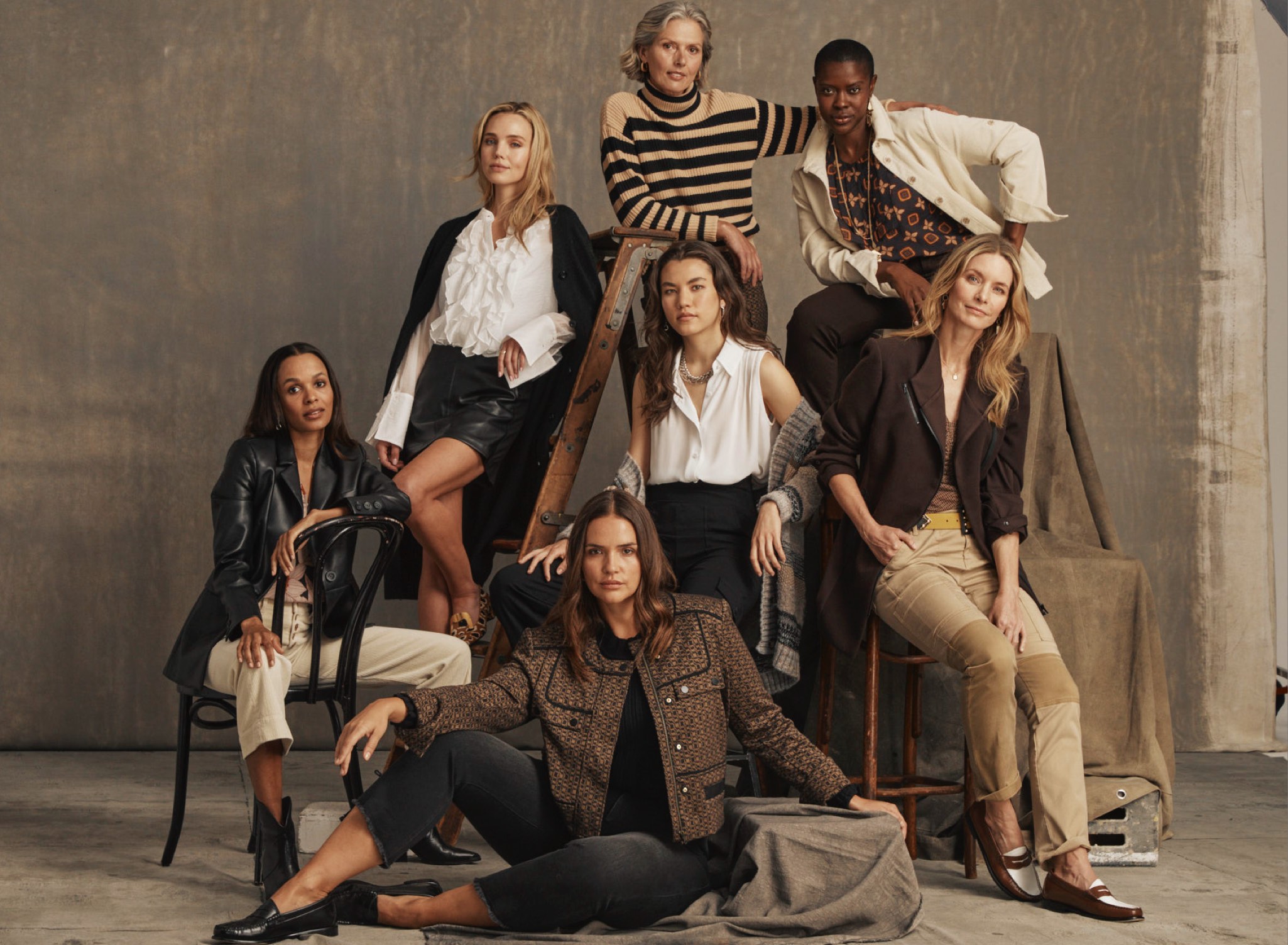 Models modeling the Fall 2023 Collection. First model is wearing Meadow Top in Daisy Print, Palm Beach Crop in Bone, and James Jacket in Black. Second model is wearing Noble Blouse in White, Jett Skort in Black, James Jacket in Black. Third model is wearing Polo Turtleneck in Black and Cream and Director Trouser in Multi. Fourth model is wearing Louis Top in Medallion Print, Scout Jacket in Bone, and Compass Pant in Dark Chocolate. Fifth model is wearing Poetry Top in White, Boyfriend Cardigan in Multi, and Chargo in Black. Sixth model is wearing Sassy Top in Tile Print, Legacy Topper in Dark Chocolate, and Captain Pant in Khaki. Seventh model is wearing Starlet Shell in Black, High-Low Crop in Washed Black, and Director Jacket in Multi.