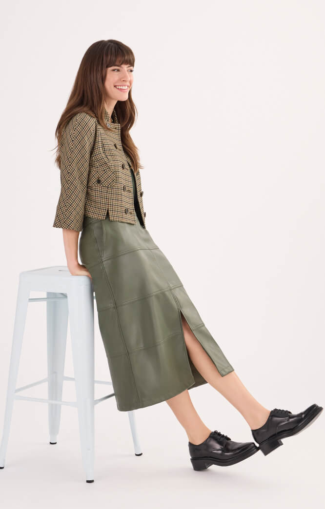 Model wearing Showroom Jacket in Houndstooth, Complete Top in Olive, and Kick It Skirt in Moss.