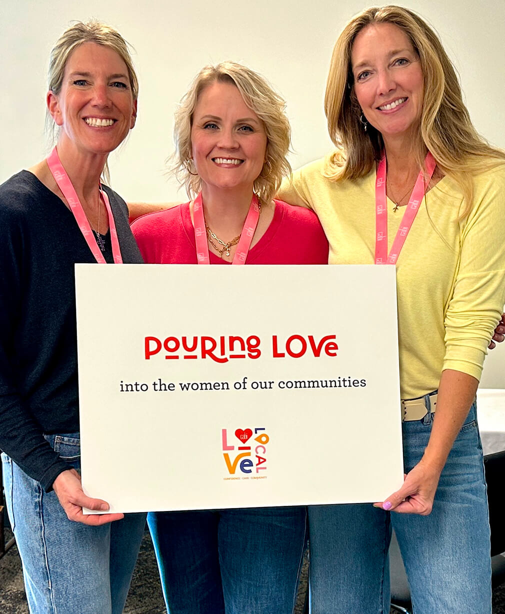 A photo showing 3 cabi Stylists holding a sign that reads 
