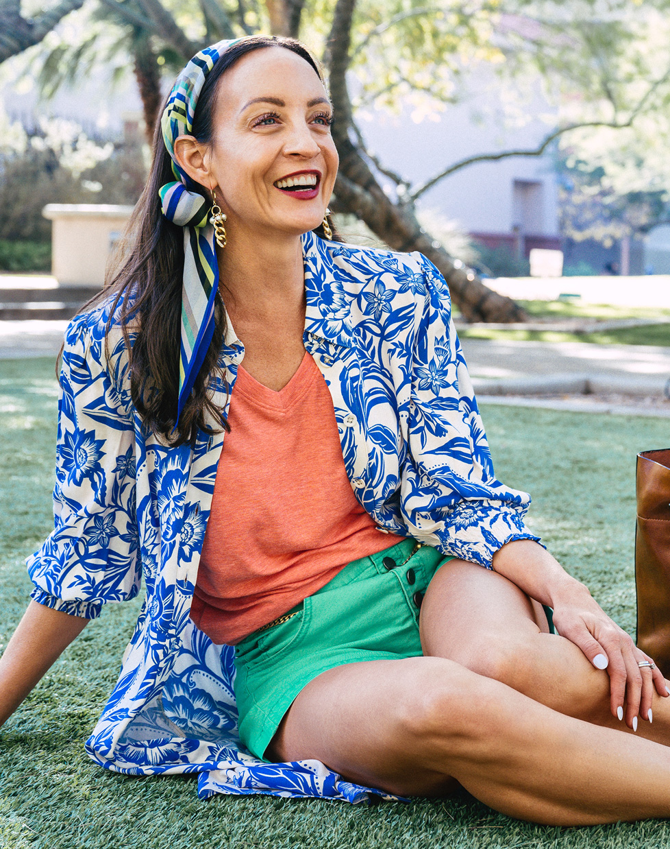 cabi Stylist wearing Serenity Tee in Cantaloupe, Button Fly Short in Waterfall, Athena Dress in Athena Tropical, Baseline Scarf in Circus Stripe, and Wisdom Earrings in Gold.